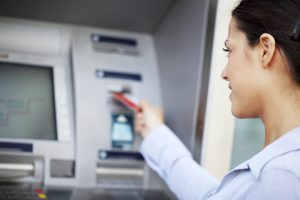 Woman put her credit card at the ATM.