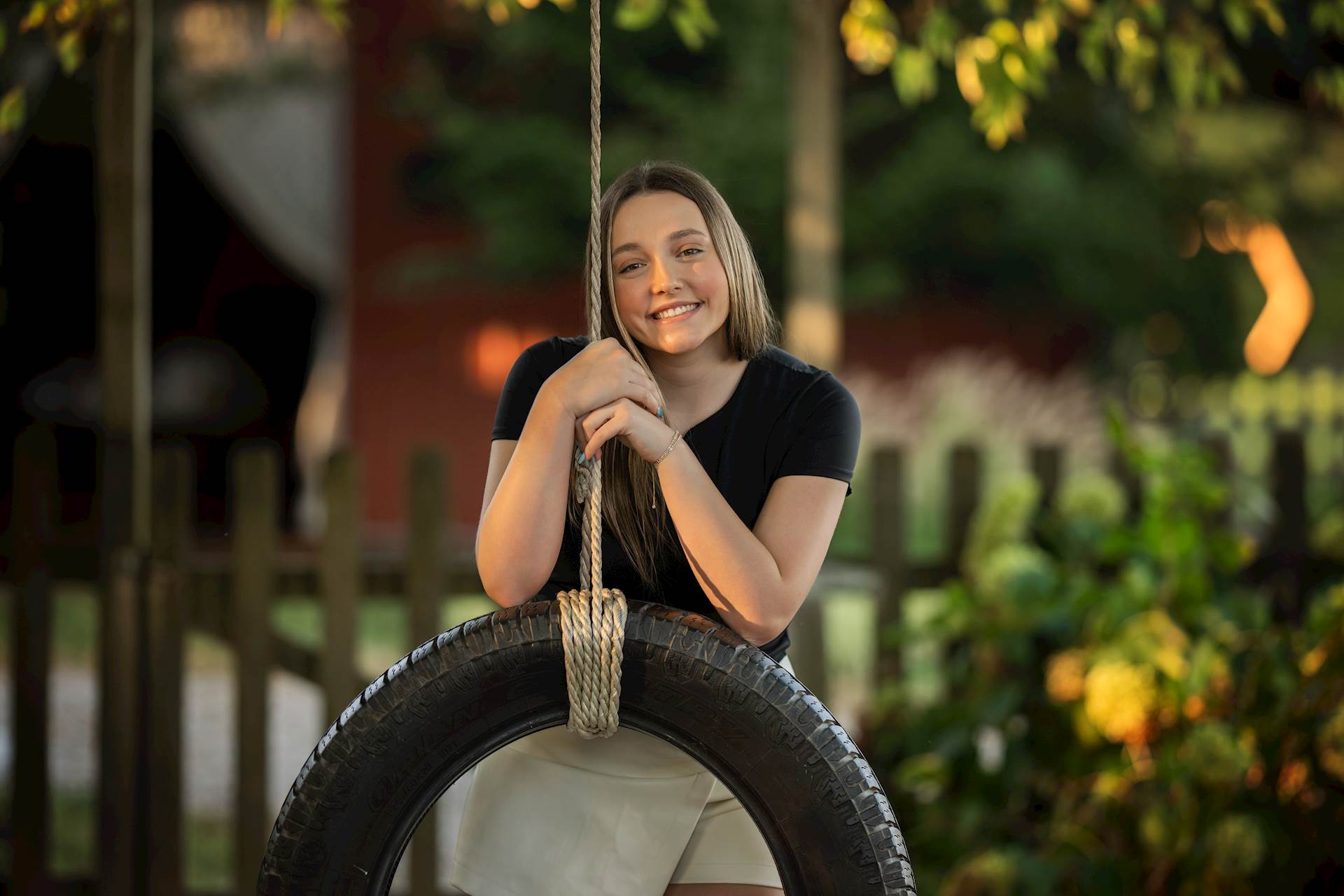 Abigail Jones smiling while holding onto a tire swing