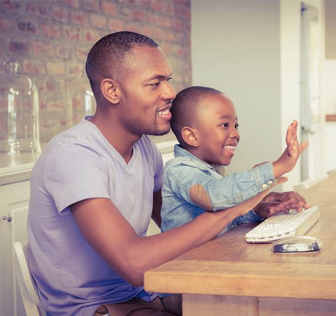 A father and son looking at a computer screen