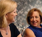 image of two employees during a meeting smiling and talking.