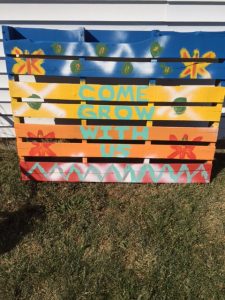 brightly colored pallet reads "Come Grow with Us."