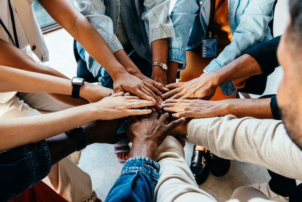 A group of people with their hands in a circle