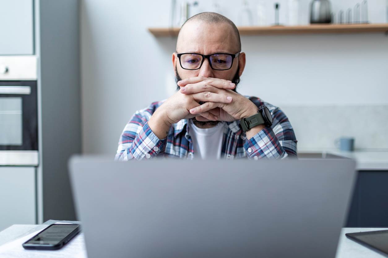 Man pensively stares at computer