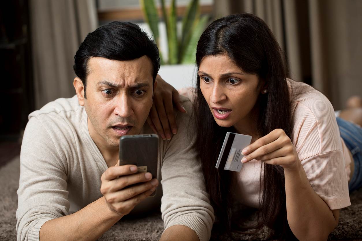 Couple looking at their phone incredulously