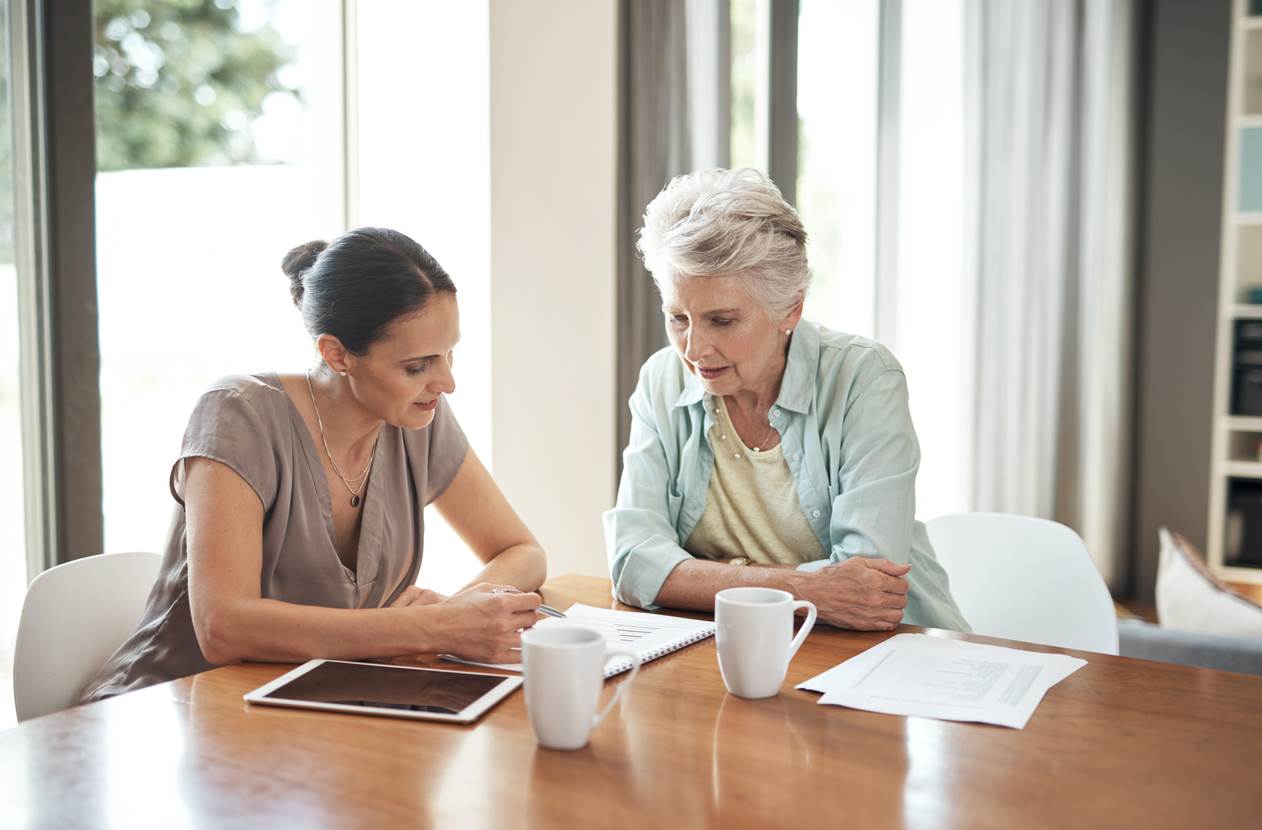 Mother and daughter talking at kitchen table