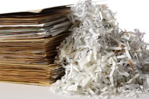 Shredded documents with stacked of with folder isolated on white background.