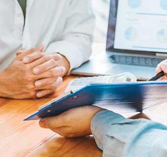 Image of meeting and someone pointing to a tablet