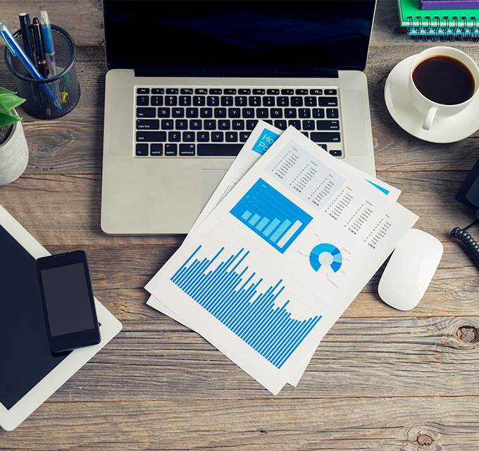 Papers with charts and graphs sitting on top of a desk