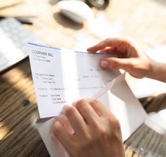 Image of person opening check to show business checking and deposits