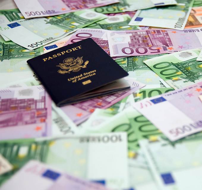 Passport sitting on top of foreign currency