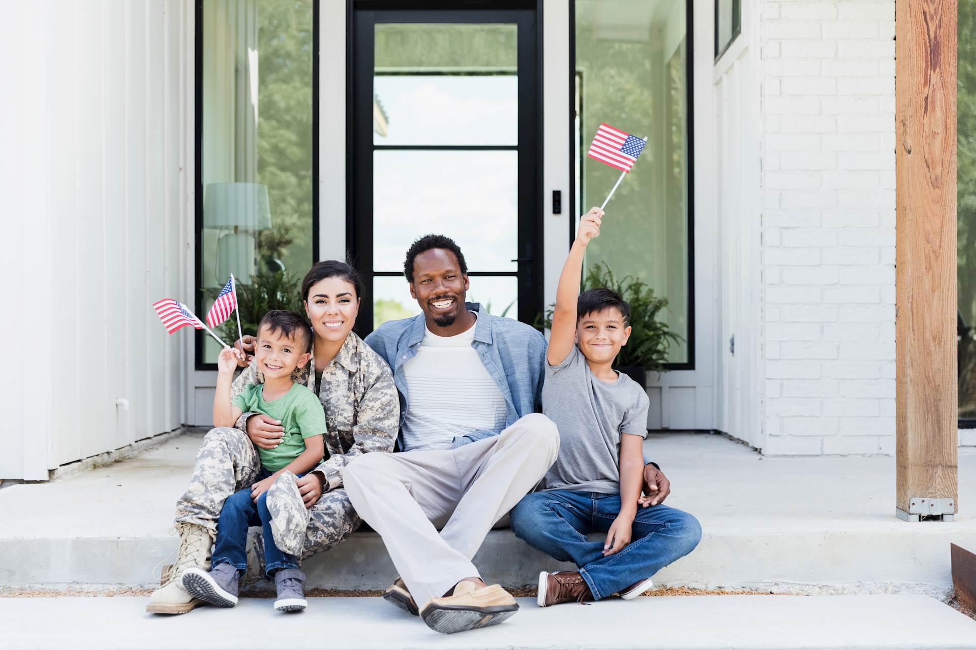 A family smies for the camera waving flags